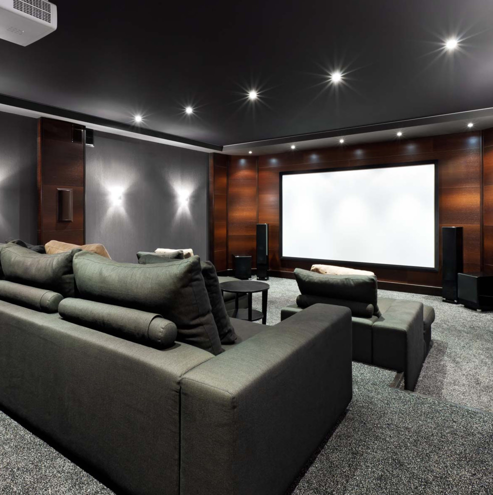 Exemple d'une très grande salle de cinéma moderne fermée avec un mur gris, moquette, un écran de projection et un sol gris.