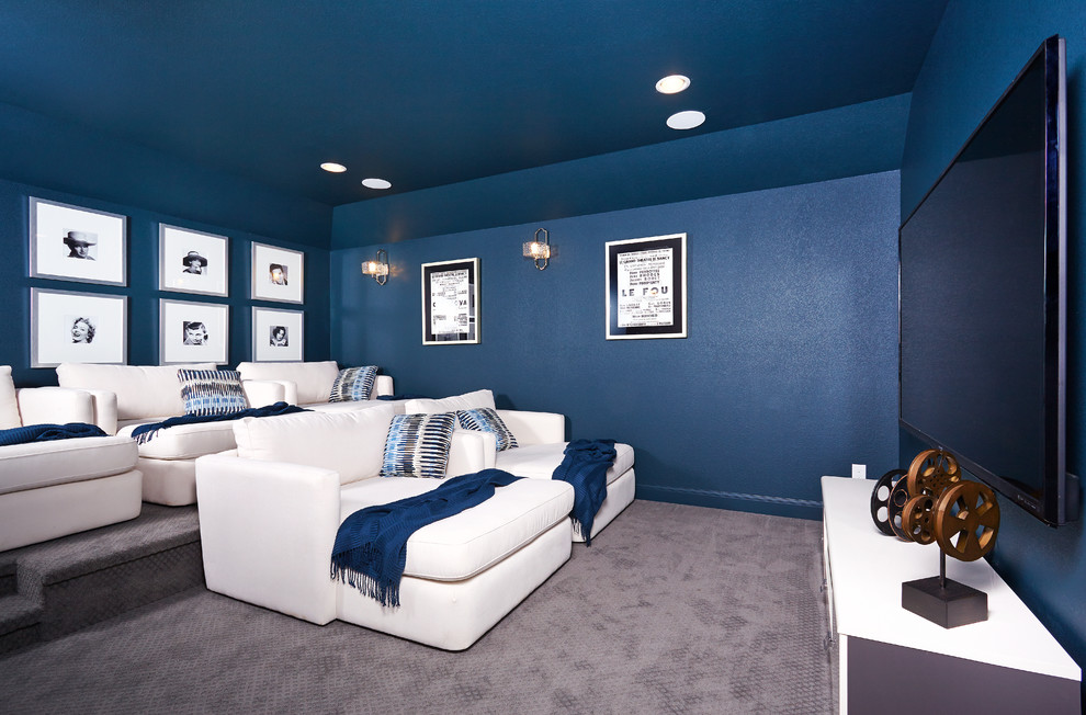 Imagen de cine en casa cerrado de tamaño medio con paredes azules, moqueta y televisor colgado en la pared