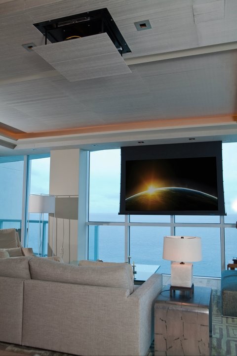 This is an example of a medium sized contemporary open plan home cinema in Miami with a projector screen.