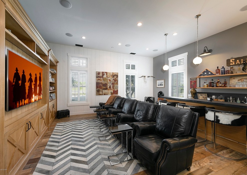 Inspiration for a mid-sized country open concept medium tone wood floor and brown floor home theater remodel in Orange County with white walls and a media wall