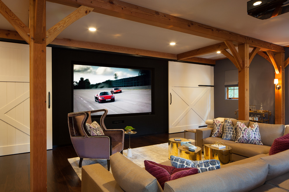 Foto de cine en casa cerrado campestre con paredes grises, suelo de madera oscura, pantalla de proyección y suelo marrón