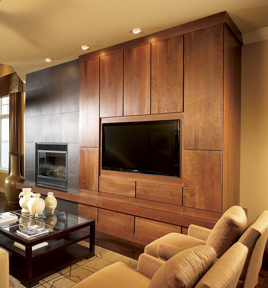 Diseño de cine en casa abierto actual de tamaño medio con televisor colgado en la pared, paredes beige, suelo de madera oscura y suelo marrón