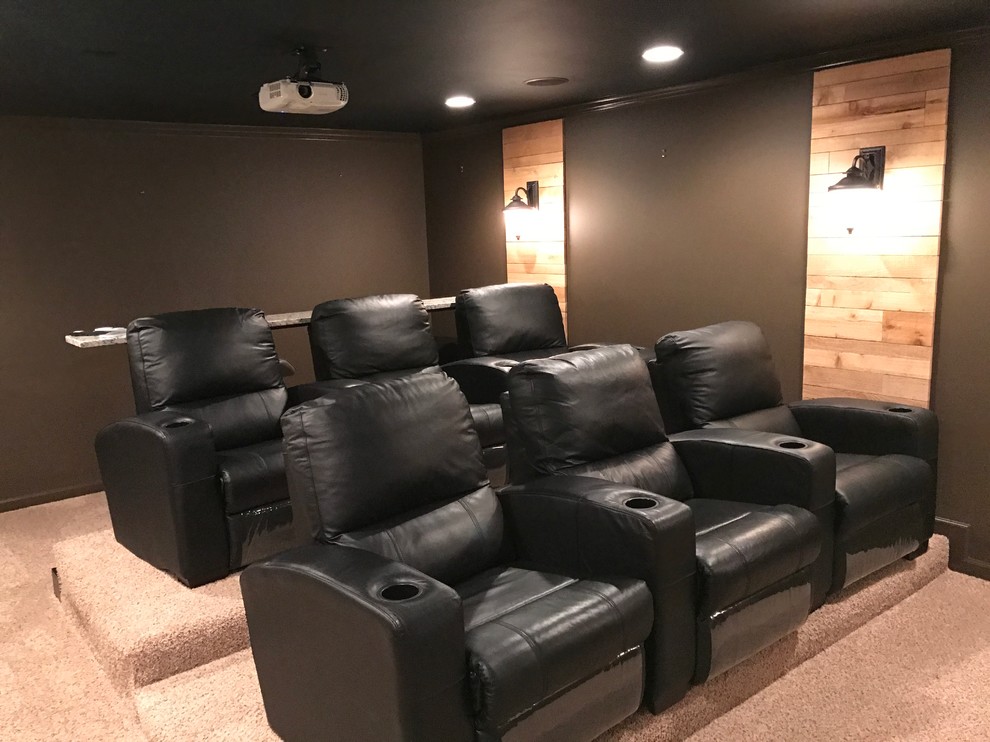 Стильный дизайн: большой изолированный домашний кинотеатр в стиле лофт с черными стенами, ковровым покрытием и проектором - последний тренд