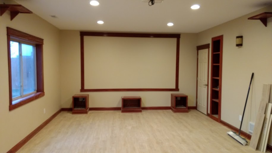 Foto di un home theatre tradizionale di medie dimensioni e aperto con pareti beige, pavimento in laminato, schermo di proiezione e pavimento beige