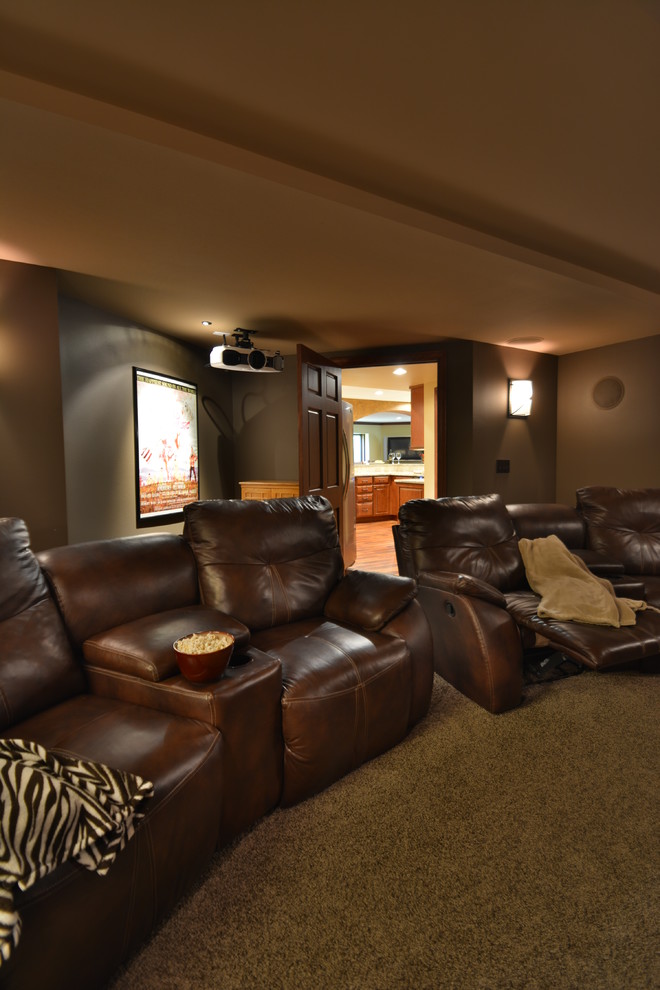 На фото: изолированный домашний кинотеатр среднего размера в средиземноморском стиле с коричневыми стенами, ковровым покрытием и проектором с