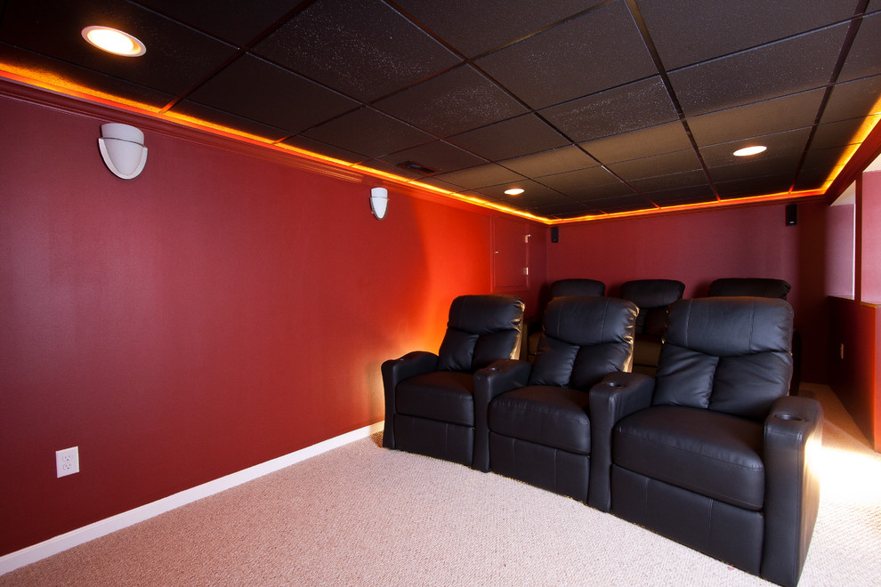 Ejemplo de cine en casa abierto actual de tamaño medio con paredes rojas, moqueta y pared multimedia