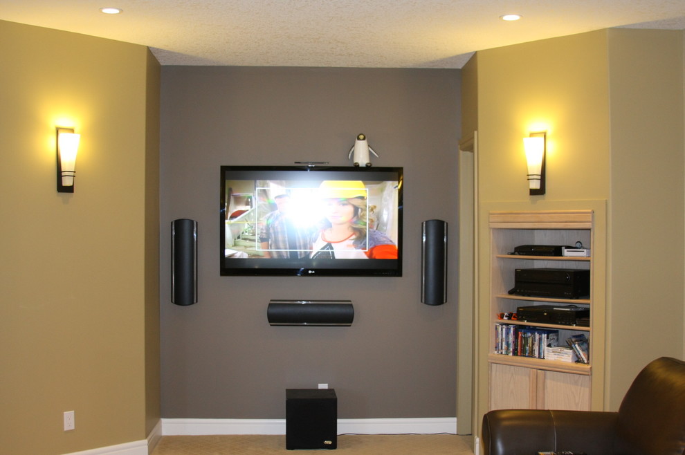 Diseño de cine en casa cerrado tradicional de tamaño medio con paredes grises, moqueta, televisor colgado en la pared y suelo beige