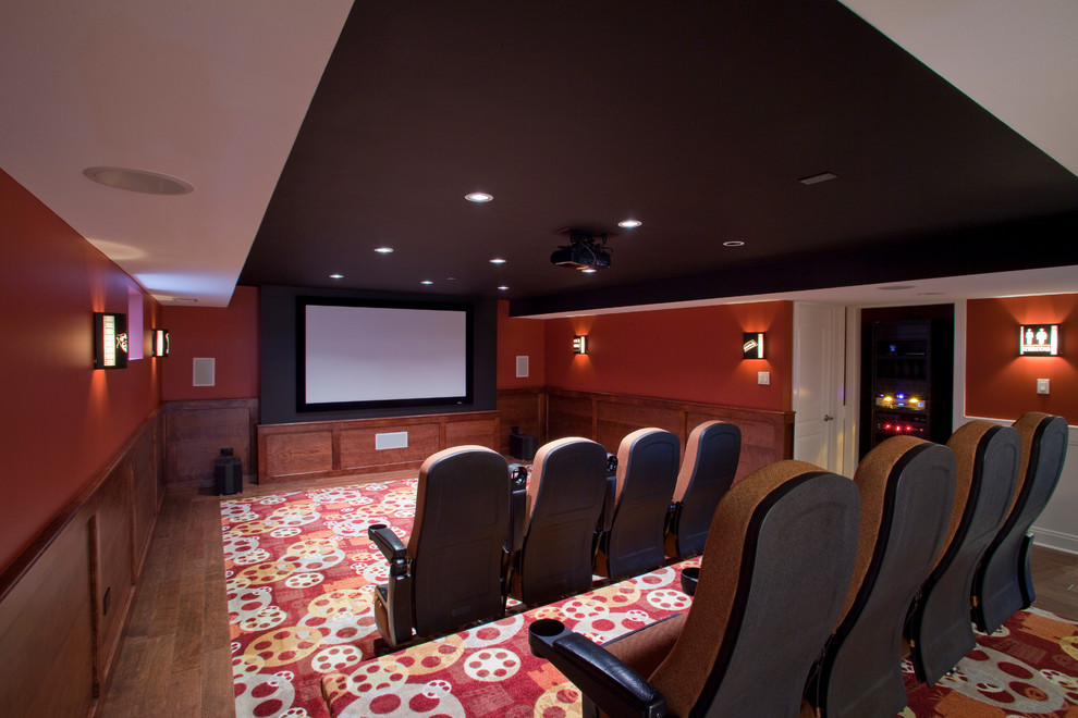 Cette photo montre une salle de cinéma tendance fermée avec un mur rouge et un écran de projection.