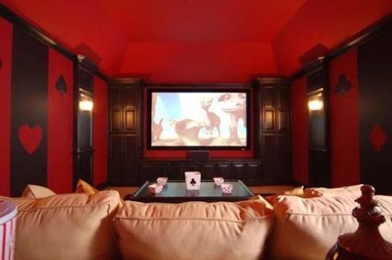 Foto di un home theatre tradizionale di medie dimensioni e chiuso con pareti rosse, moquette e parete attrezzata