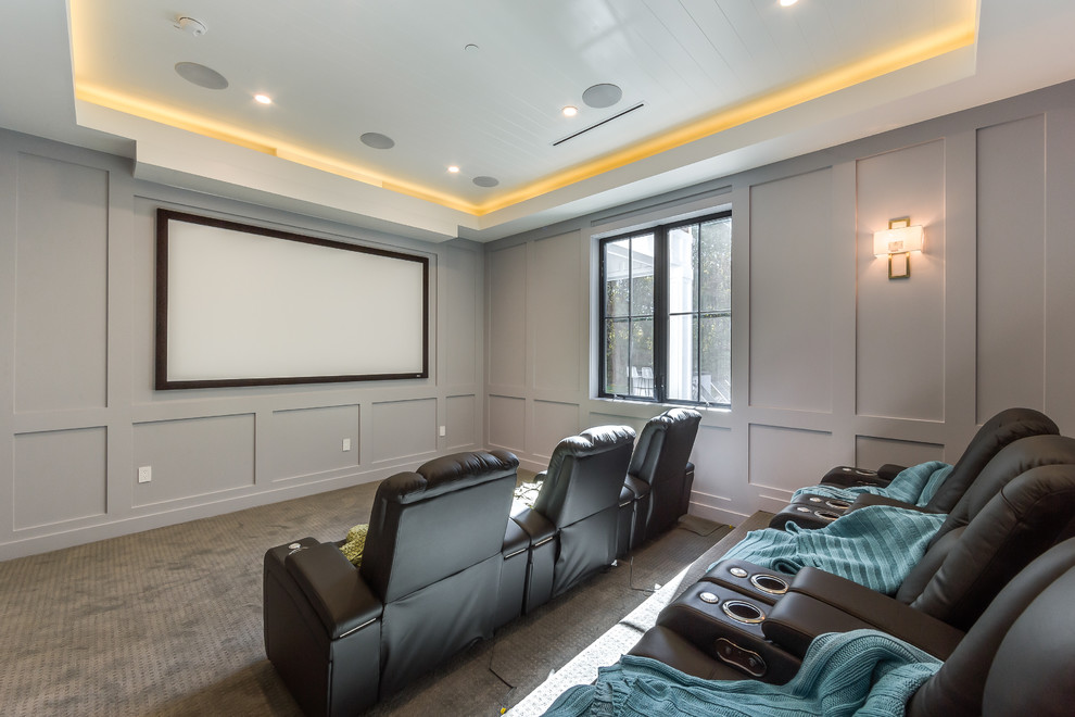 На фото: изолированный домашний кинотеатр среднего размера в стиле неоклассика (современная классика) с серыми стенами, ковровым покрытием, проектором и серым полом с