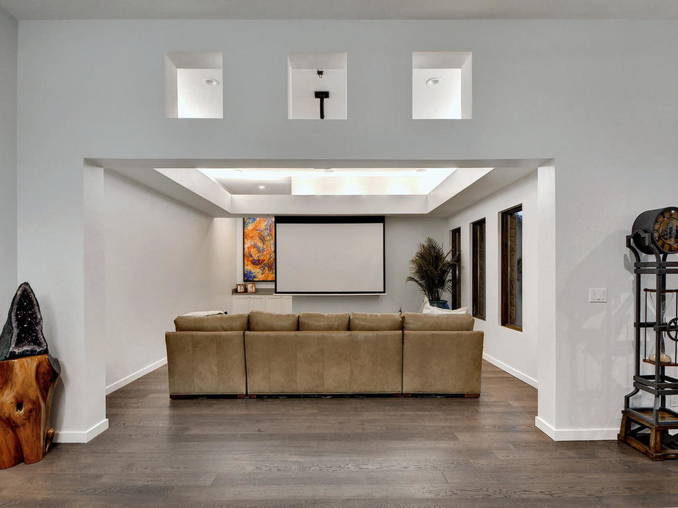 Photo of a large contemporary open plan home cinema in Austin with white walls, dark hardwood flooring, a projector screen and brown floors.
