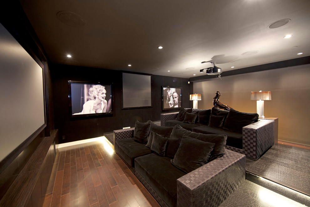 Imagen de cine en casa cerrado actual grande con paredes grises, moqueta y pantalla de proyección