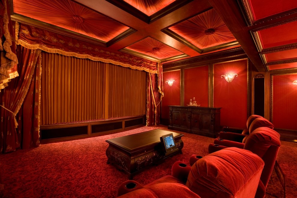 Ejemplo de cine en casa cerrado clásico con paredes rojas, pantalla de proyección y suelo rojo