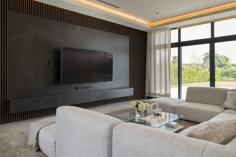 Modelo de cine en casa abierto moderno extra grande con paredes marrones, suelo de baldosas de porcelana, televisor colgado en la pared y suelo gris