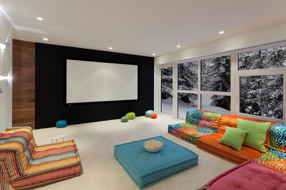 Idée de décoration pour une salle de cinéma design avec un mur blanc, moquette, un écran de projection et un sol beige.