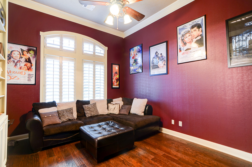 Mittelgroßes Klassisches Heimkino mit roter Wandfarbe, dunklem Holzboden und TV-Wand in Austin