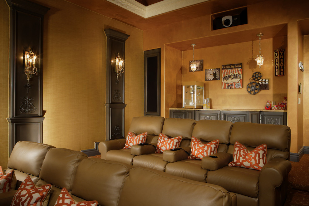 На фото: огромный изолированный домашний кинотеатр в классическом стиле с оранжевыми стенами, ковровым покрытием и проектором с