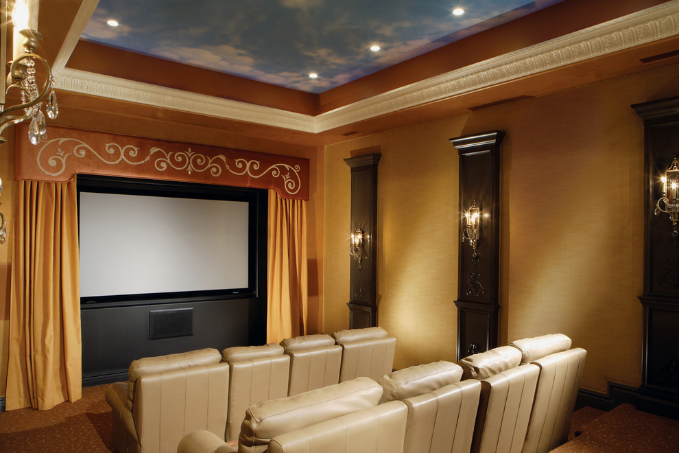 Diseño de cine en casa cerrado clásico renovado extra grande con parades naranjas, moqueta y pantalla de proyección