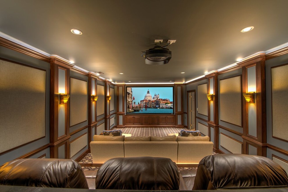 Idée de décoration pour une grande salle de cinéma tradition fermée avec un mur gris, un sol en bois brun, un écran de projection et un sol multicolore.