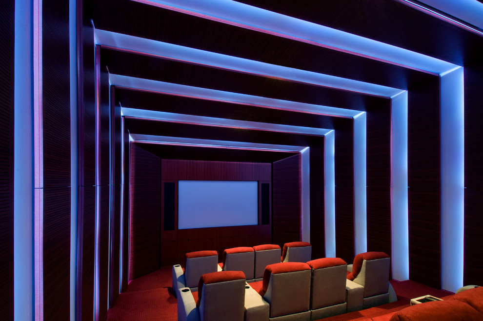Стильный дизайн: изолированный домашний кинотеатр в современном стиле с коричневыми стенами, ковровым покрытием, проектором и оранжевым полом - последний тренд