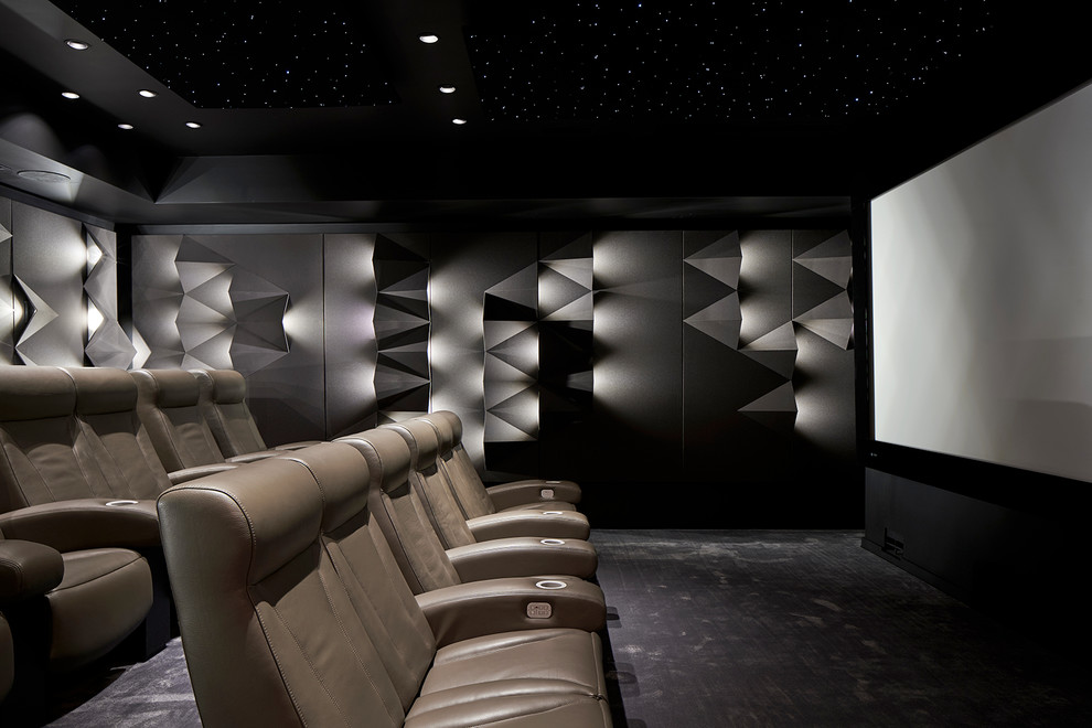 Cette image montre une grande salle de cinéma design fermée avec un mur gris, moquette, un écran de projection et un sol gris.