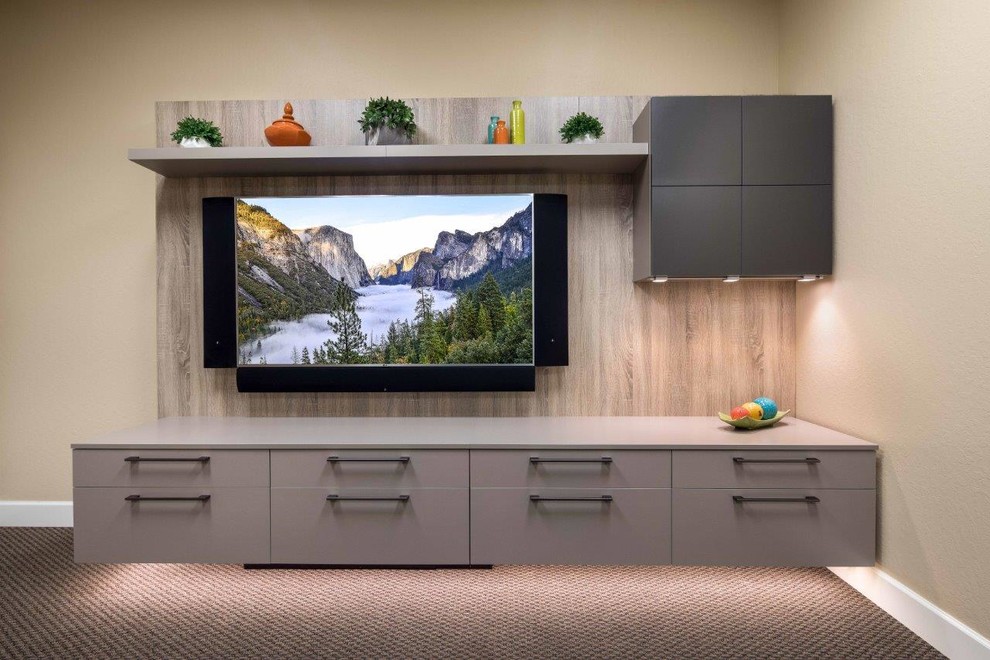 Imagen de cine en casa abierto actual de tamaño medio con paredes beige, moqueta, televisor colgado en la pared y suelo multicolor