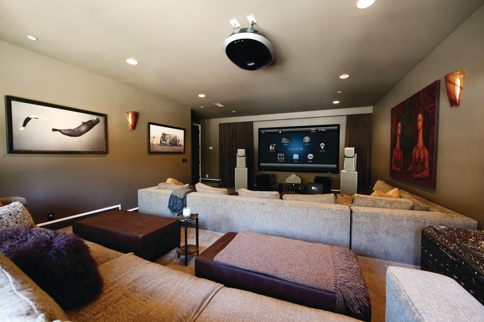 Ejemplo de cine en casa abierto mediterráneo de tamaño medio con paredes beige, moqueta, televisor colgado en la pared y suelo beige