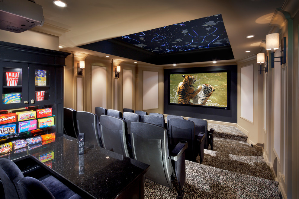 На фото: большой изолированный домашний кинотеатр в стиле неоклассика (современная классика) с бежевыми стенами, ковровым покрытием, проектором и разноцветным полом