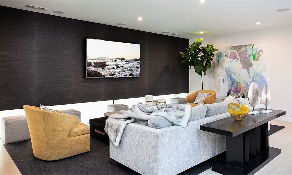 Modern inredning av ett stort avskild hemmabio, med vita väggar, kalkstensgolv, en väggmonterad TV och beiget golv