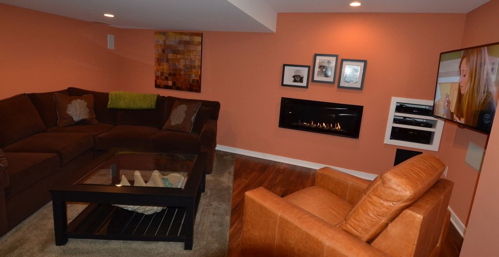 Imagen de cine en casa abierto contemporáneo con suelo de madera en tonos medios y televisor colgado en la pared
