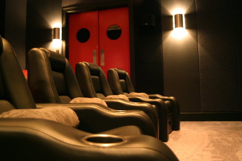 Пример оригинального дизайна: большой изолированный домашний кинотеатр в современном стиле с черными стенами, ковровым покрытием и серым полом