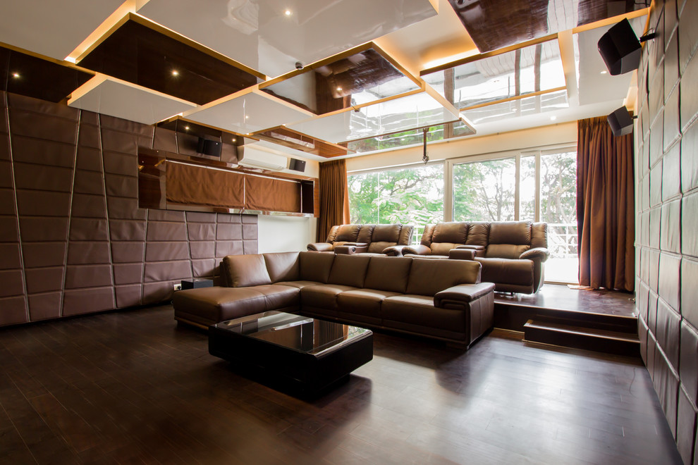 Diseño de cine en casa cerrado actual grande con paredes blancas, suelo de madera oscura y pantalla de proyección