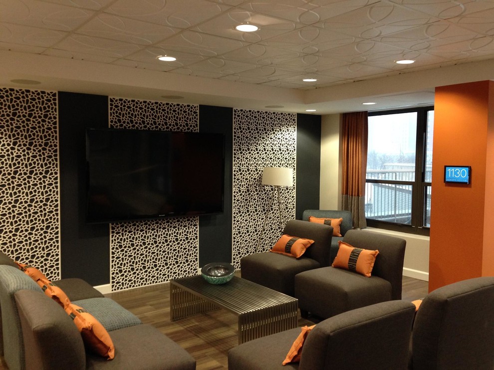 Mittelgroßes Modernes Heimkino mit TV-Wand, bunten Wänden und hellem Holzboden in Chicago