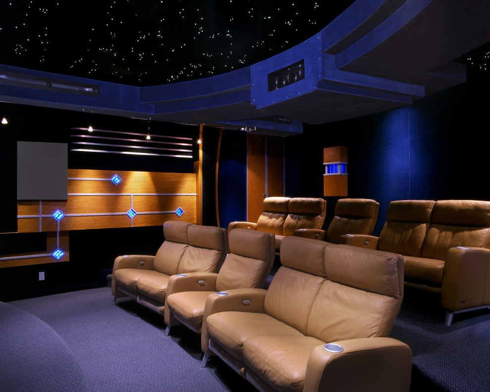 Пример оригинального дизайна: огромный изолированный домашний кинотеатр в современном стиле с черными стенами, ковровым покрытием, проектором и синим полом