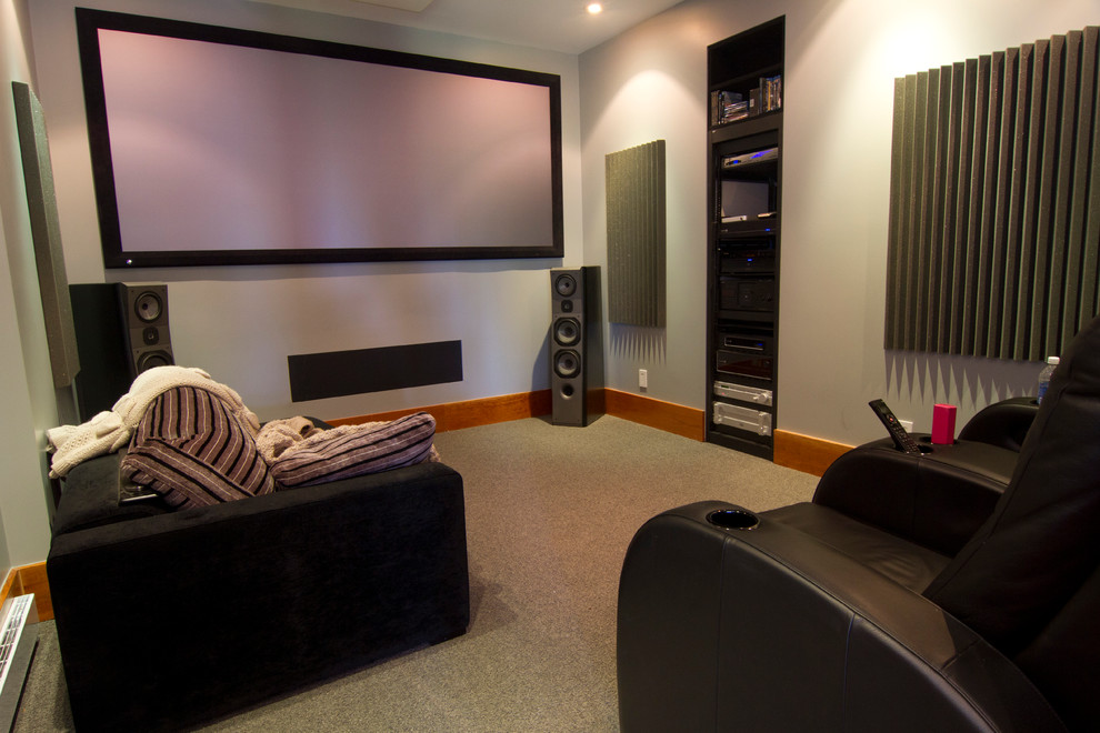 Cette image montre une petite salle de cinéma design fermée avec un mur bleu, moquette et un écran de projection.