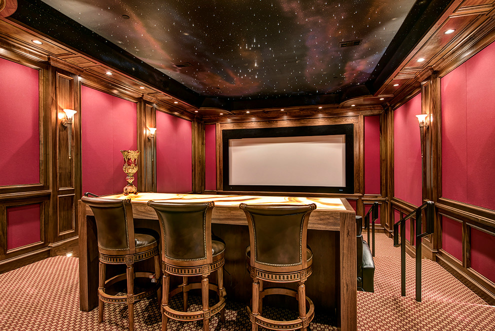 Aménagement d'une grande salle de cinéma classique fermée avec un mur rouge, moquette, un écran de projection et un sol multicolore.