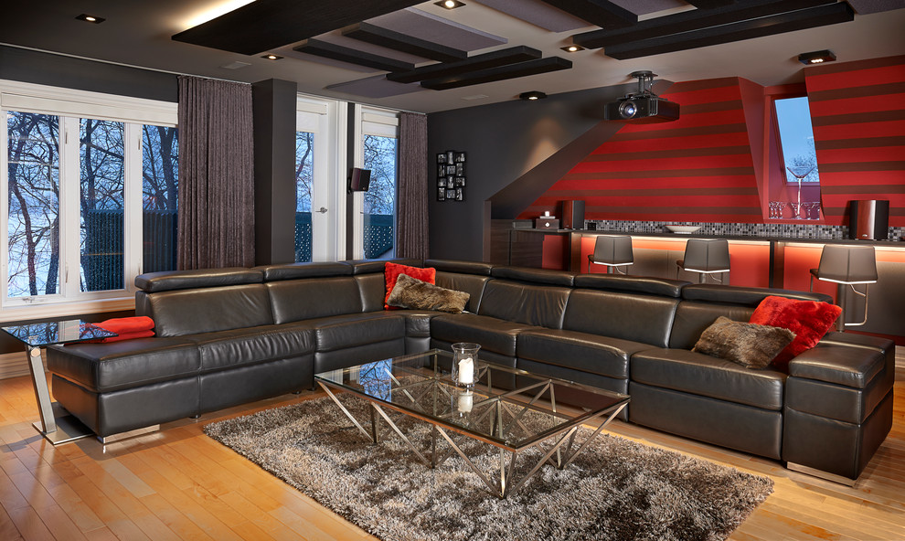 Modelo de cine en casa contemporáneo con paredes rojas, pantalla de proyección y suelo de madera en tonos medios
