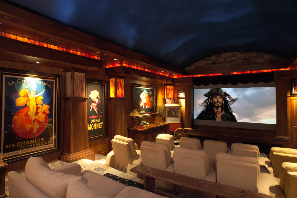 На фото: большой изолированный домашний кинотеатр в стиле кантри с проектором, коричневыми стенами и ковровым покрытием с