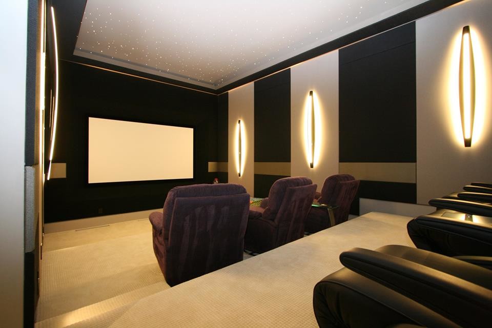 Ejemplo de cine en casa cerrado contemporáneo grande con paredes multicolor, moqueta, pantalla de proyección y suelo beige