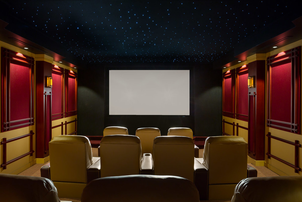 Cette photo montre une grande salle de cinéma tendance fermée avec un mur rouge, moquette et un écran de projection.