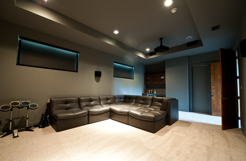 Modelo de cine en casa contemporáneo con paredes grises y moqueta