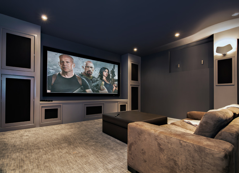 Modelo de cine en casa cerrado actual de tamaño medio con paredes grises, moqueta y pantalla de proyección