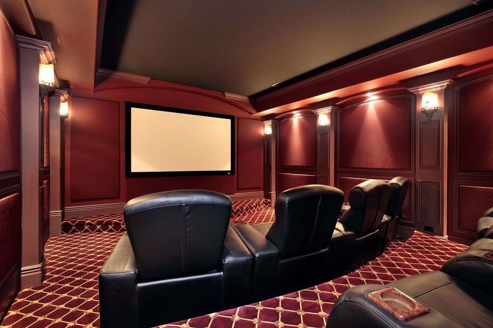 Diseño de cine en casa cerrado tradicional grande con paredes rojas, moqueta, pantalla de proyección y suelo rojo