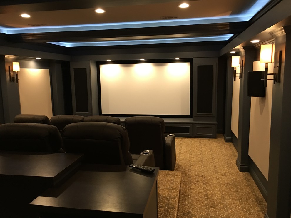 Immagine di un grande home theatre classico chiuso con pareti nere, moquette, schermo di proiezione e pavimento beige