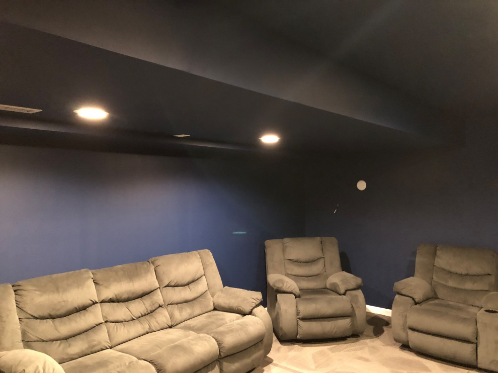 Idée de décoration pour une salle de cinéma design de taille moyenne et fermée avec un mur bleu, moquette, un écran de projection et un sol gris.