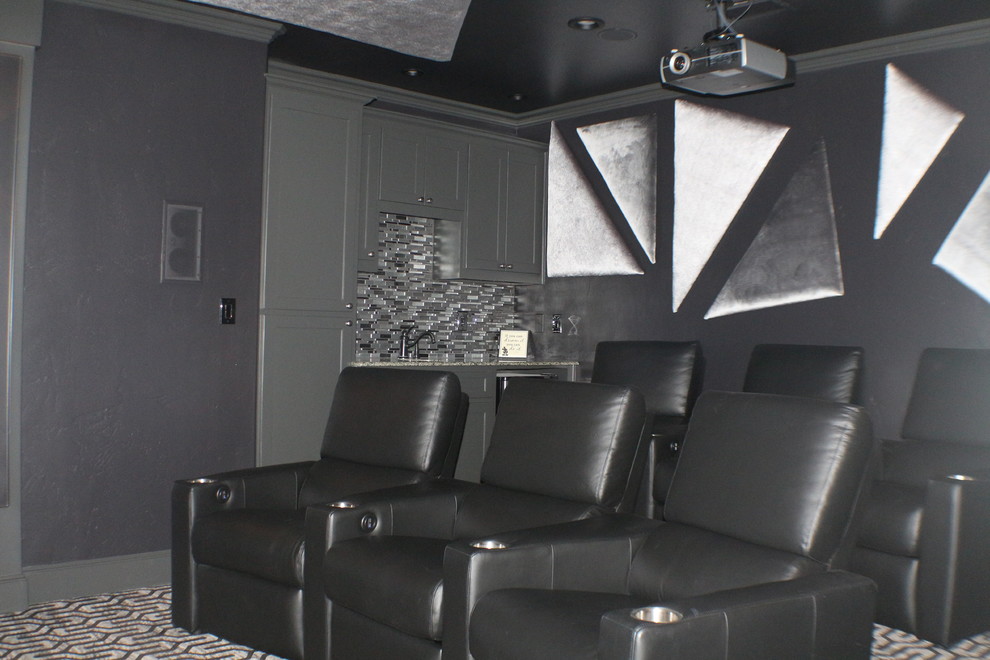 Modelo de cine en casa cerrado contemporáneo de tamaño medio con paredes negras, moqueta, pantalla de proyección y suelo gris