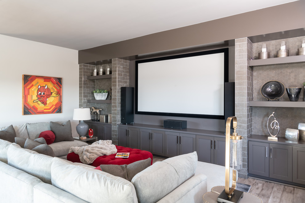 Inspiration for a large contemporary open plan home cinema in Austin with grey walls, medium hardwood flooring, a projector screen and grey floors.