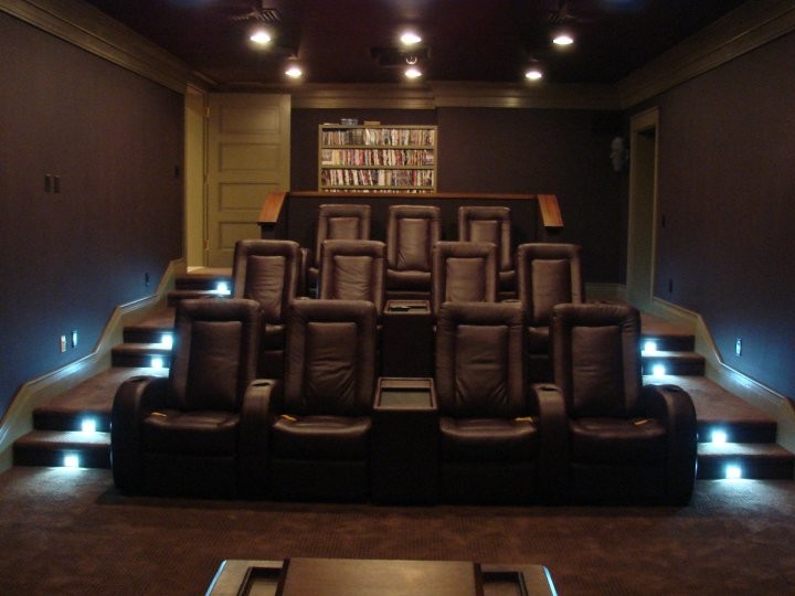Example of a carpeted home theater design in Boston with purple walls
