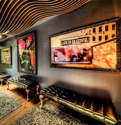 Cette image montre une petite salle de cinéma minimaliste fermée avec un mur bleu, un sol en bois brun et un téléviseur fixé au mur.