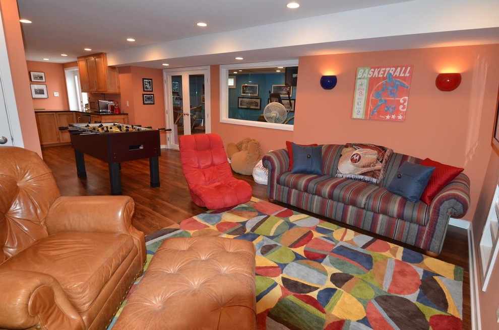 Geräumiges, Offenes Modernes Heimkino mit oranger Wandfarbe, braunem Holzboden und Multimediawand in Philadelphia